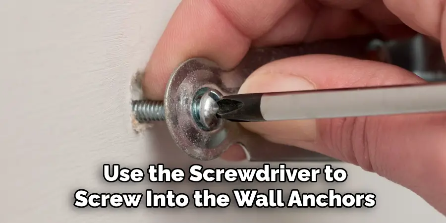 Use the Screwdriver to Screw Into the Wall Anchors