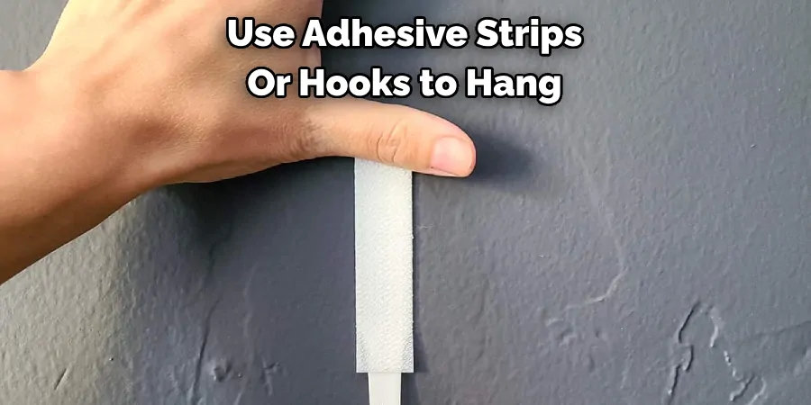 Use Adhesive Strips Or Hooks to Hang